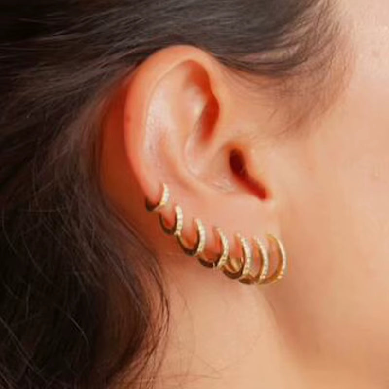 Gold crystal huggie hoop earrings with colorful stones, stacked for cartilage