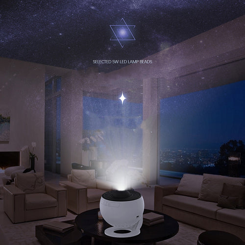 Galaxy projector night light with white body on a table, black top, projecting a glow.