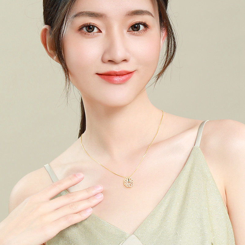 Gold clover-heart necklace with small four-leaf clover charm on chain
