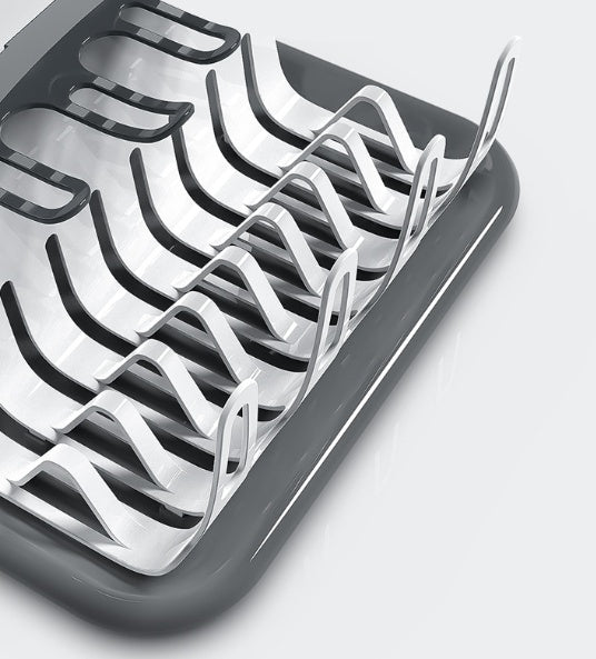 Close-up of dish drying rack wire prongs on a dark grey tray