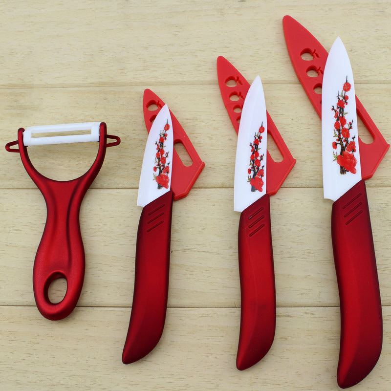 Red ceramic fruit knife set with peeler and four upright floral printed blades