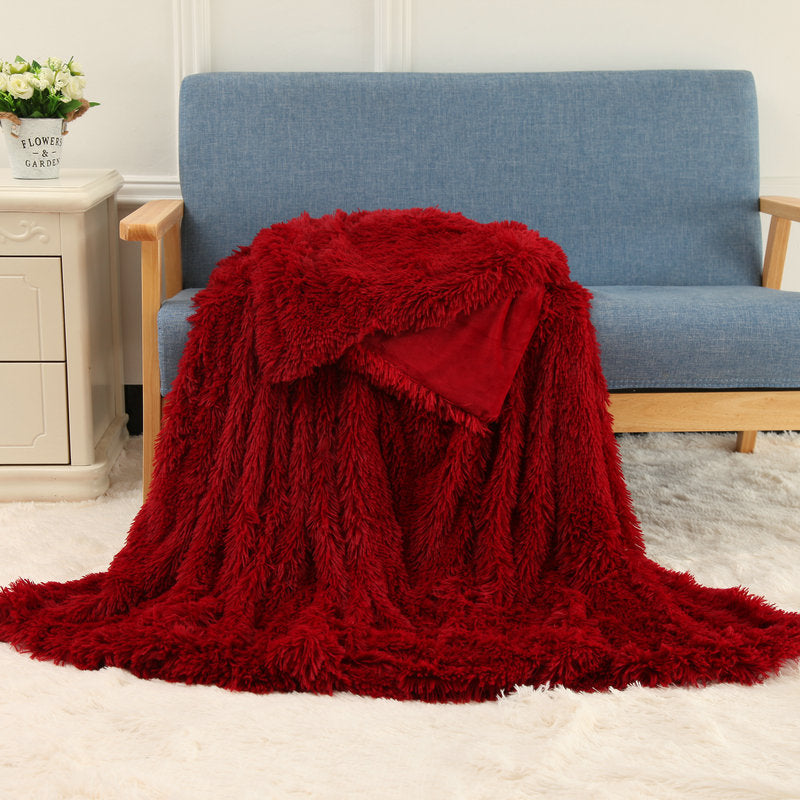 Plush throw blanket in deep red with thick shaggy pile texture