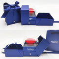 Blue jewelry gift box set with red rose in clear lid, open drawer, and blue compartments