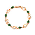 Rose gold heart bracelet with green teardrop stones and clear rhinestone heart charms.