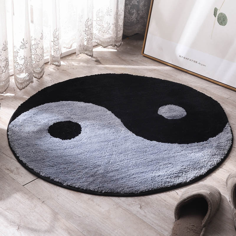 Round area rug with yin-yang style pattern, dark and light gray loops