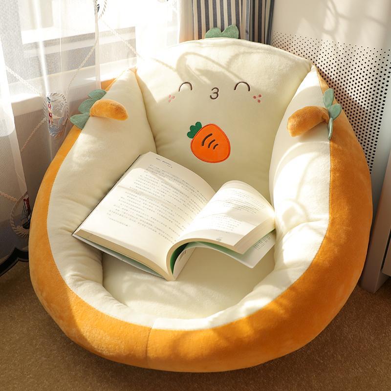 Round character floor cushion seat pad in cream with orange plush edge and cute orange face.