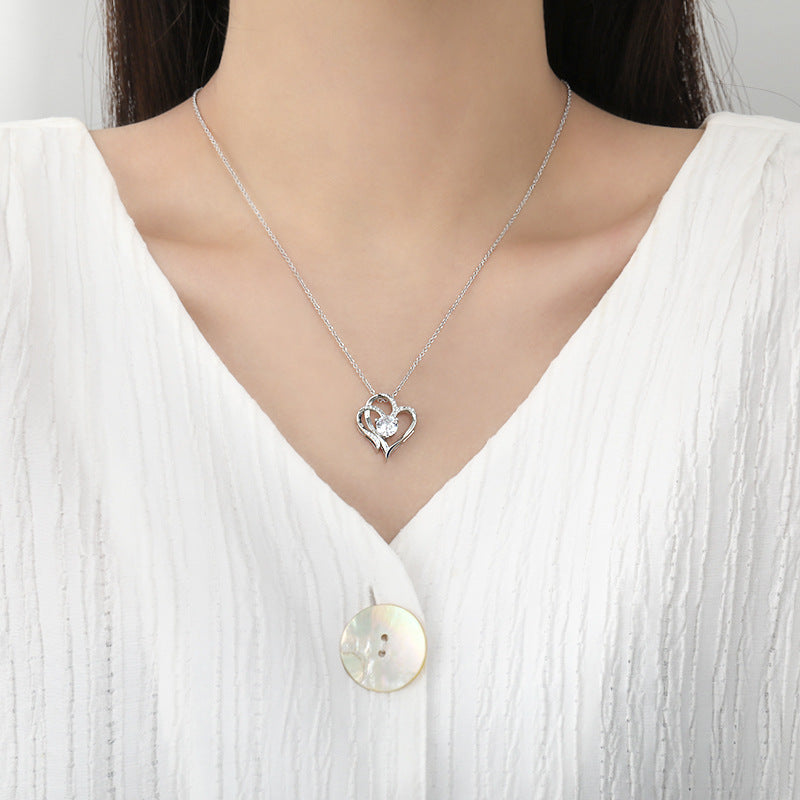 Silver heart pendant necklace with small clear stones, worn at collarbone