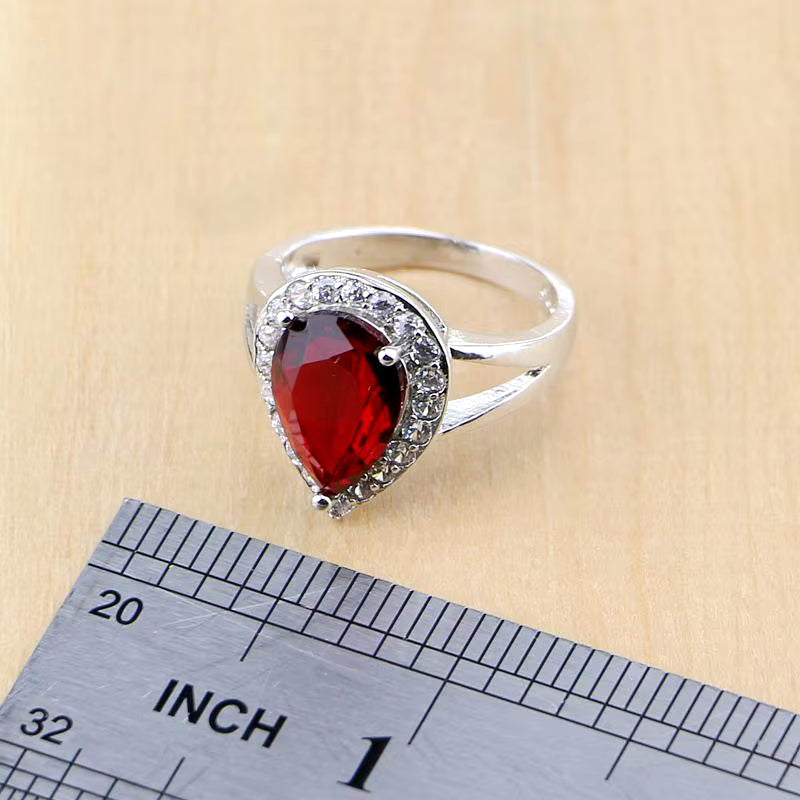 Sterling silver ring with oval red gemstone and pavé halo