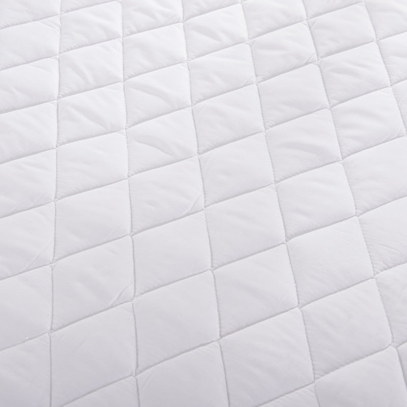 White quilted mattress topper top surface with repeating diamond pattern