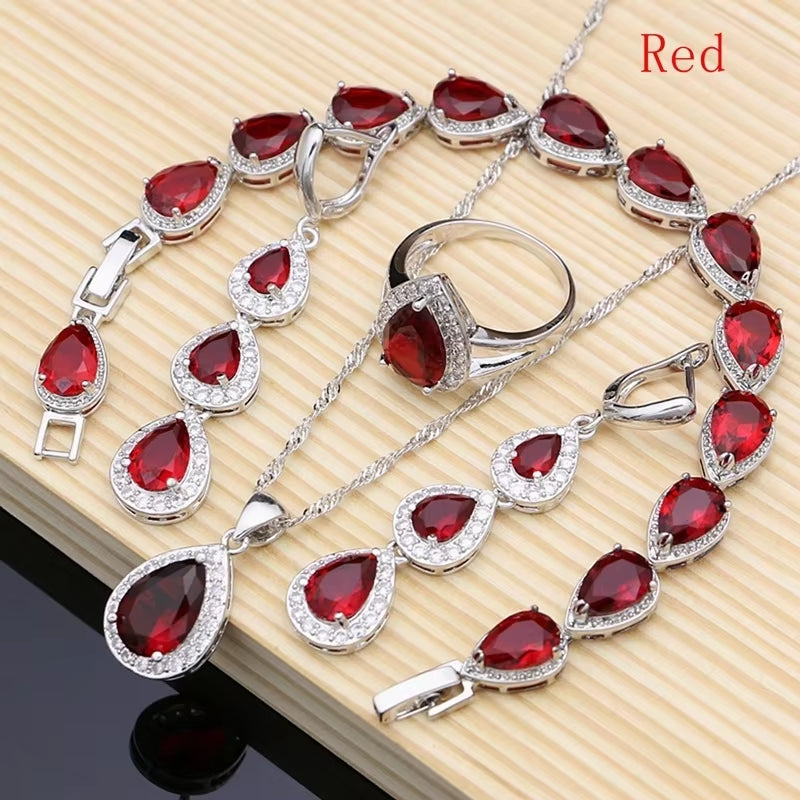 Sterling silver jewelry set with red teardrop gemstones, bracelet, earrings and ring