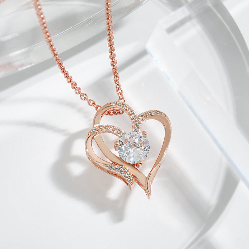 Rose gold double heart necklace with clear round center stone and pavé detail