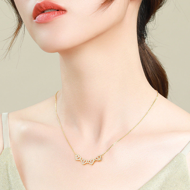 Gold clover-heart necklace with scalloped heart pendant and small crystals on chain