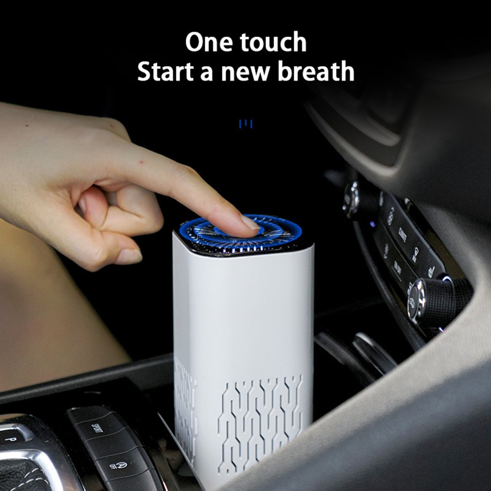 White portable air purifier with blue-lit top control button, in a car cupholder.