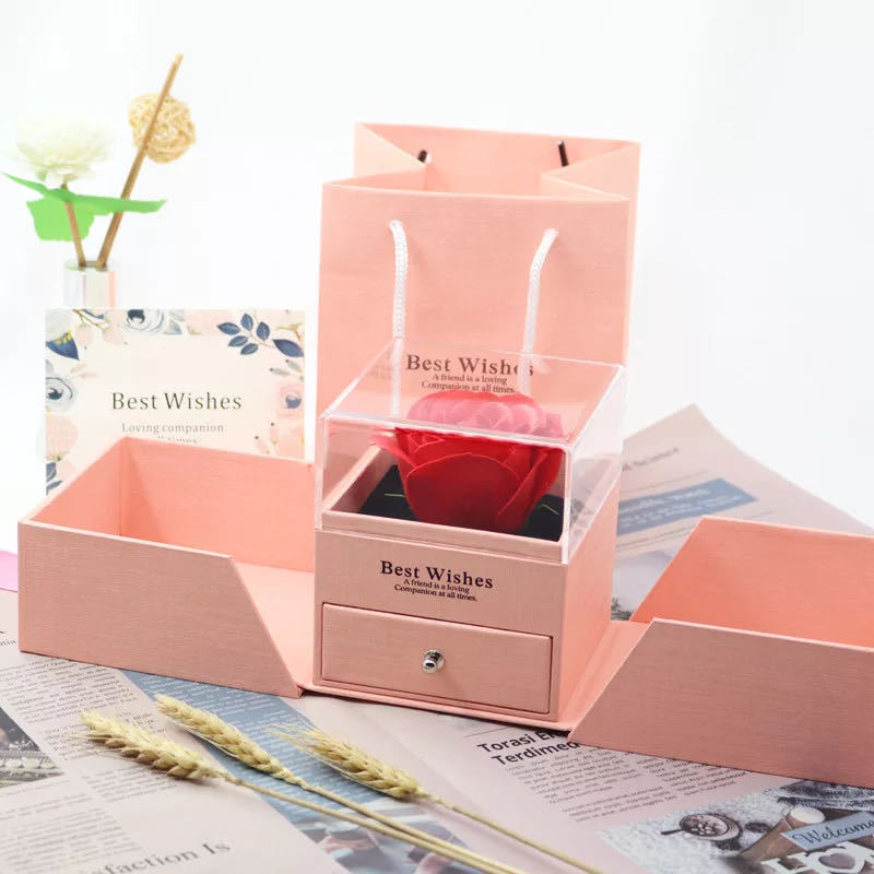 Pink jewelry gift box set with red preserved rose in clear top, open drawer and compartments