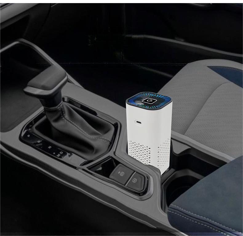 White portable air purifier with blue-lit top fan, sitting in a car cupholder.
