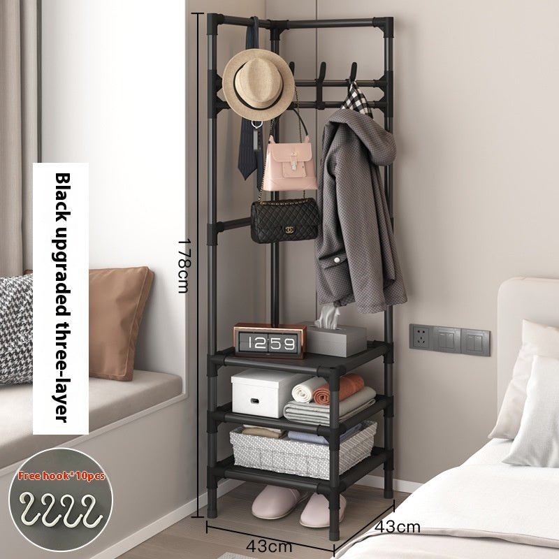 Black corner coat rack with hanging hooks holding coat, hat, and bags on storage shelves