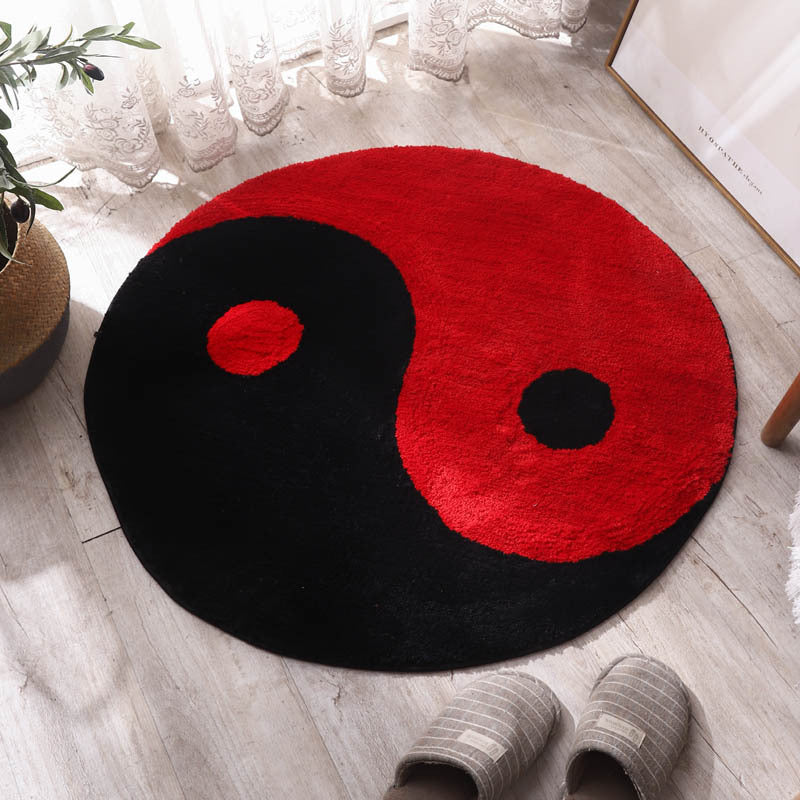 Round area rug with yin-yang style pattern, red and black split sections
