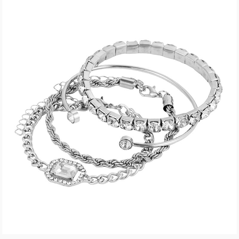 Silver-toned rhinestone bracelet set with chain links, round stones, and bangle cuffs