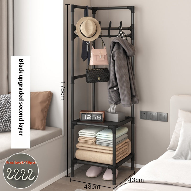 Black corner coat rack with hanging hooks and lower shelves holding folded blankets and shoes