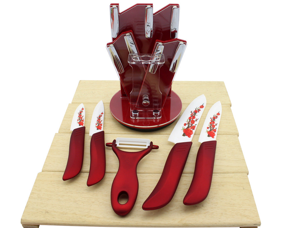 Red ceramic fruit knife set in clear stand, four floral printed knives and peeler