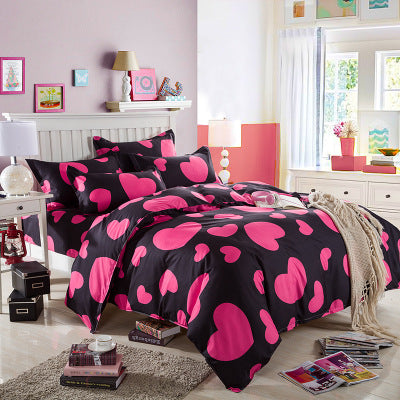 Cotton bedding set with black duvet and large pink petal heart patterns, with pillowcases