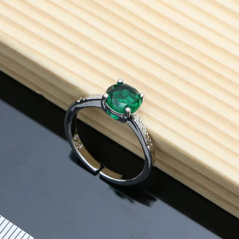 Silver ring with a green oval gemstone on a split band, prong-set center