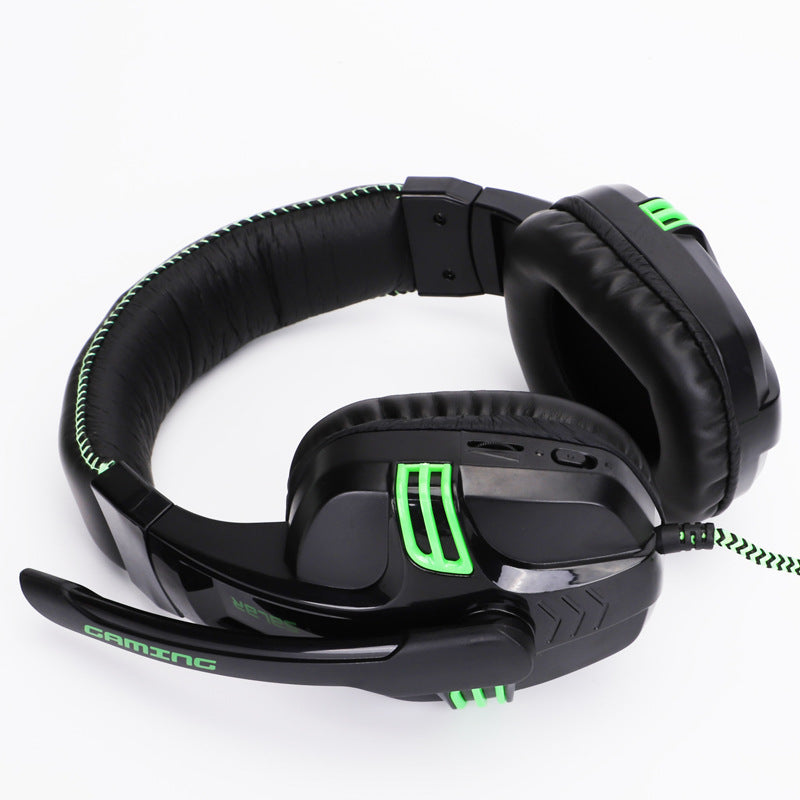 Black wired gaming headset with green accents, over-ear pads, and attached mic