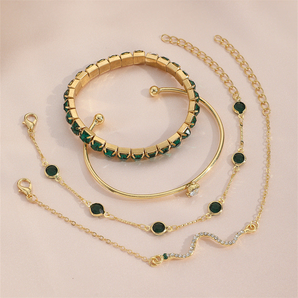 Gold-tone multi-bracelet set featuring green stone bangles and linked chain bracelets
