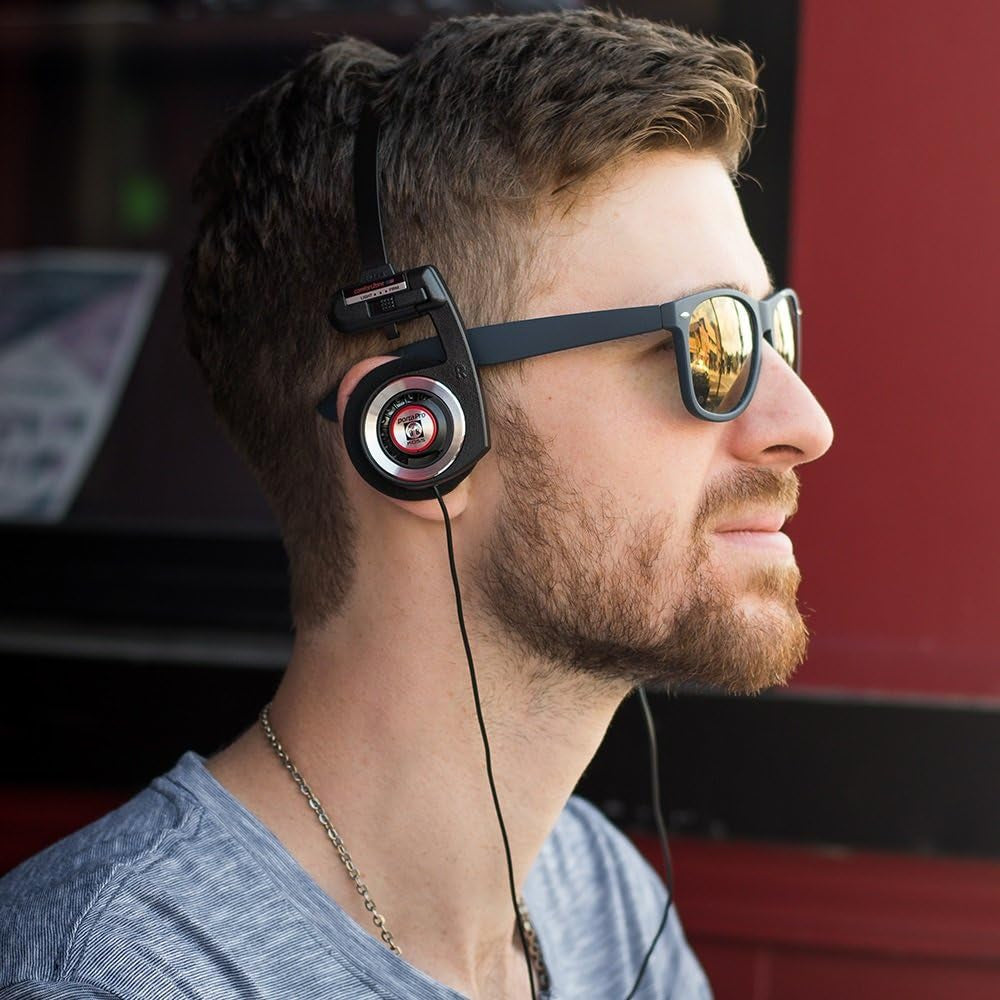 Black on-ear headphones worn over one ear with inline cable