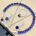 Sterling silver jewelry set with round blue gemstones: bracelet, necklace, ring, and earrings