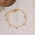 Gold-tone heart charm bracelet with white enamel heart links and chain clasp