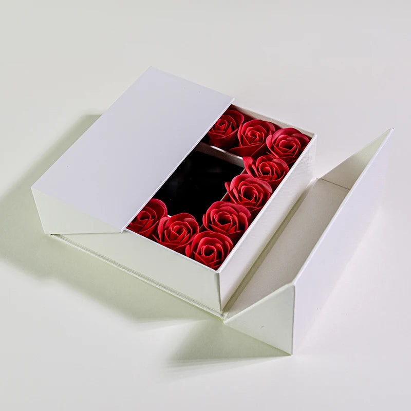 Open jewelry box gift set with red rose arrangement and black jewelry tray insert