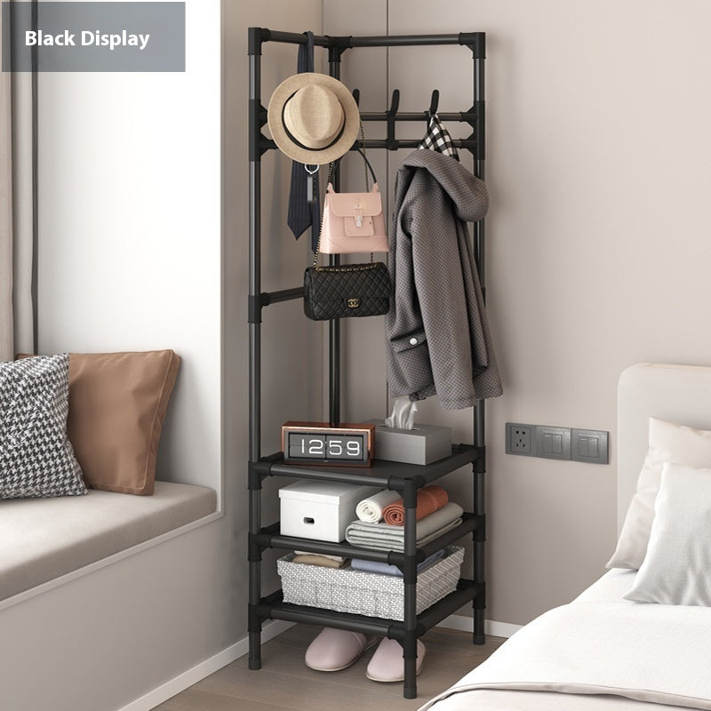 Black corner coat rack with hanging hooks holding coat, hat, and bags; open storage shelves
