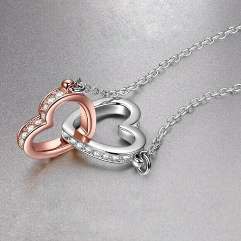Close-up heart infinity necklace pendant with rose-gold inner heart and silver-tone outer