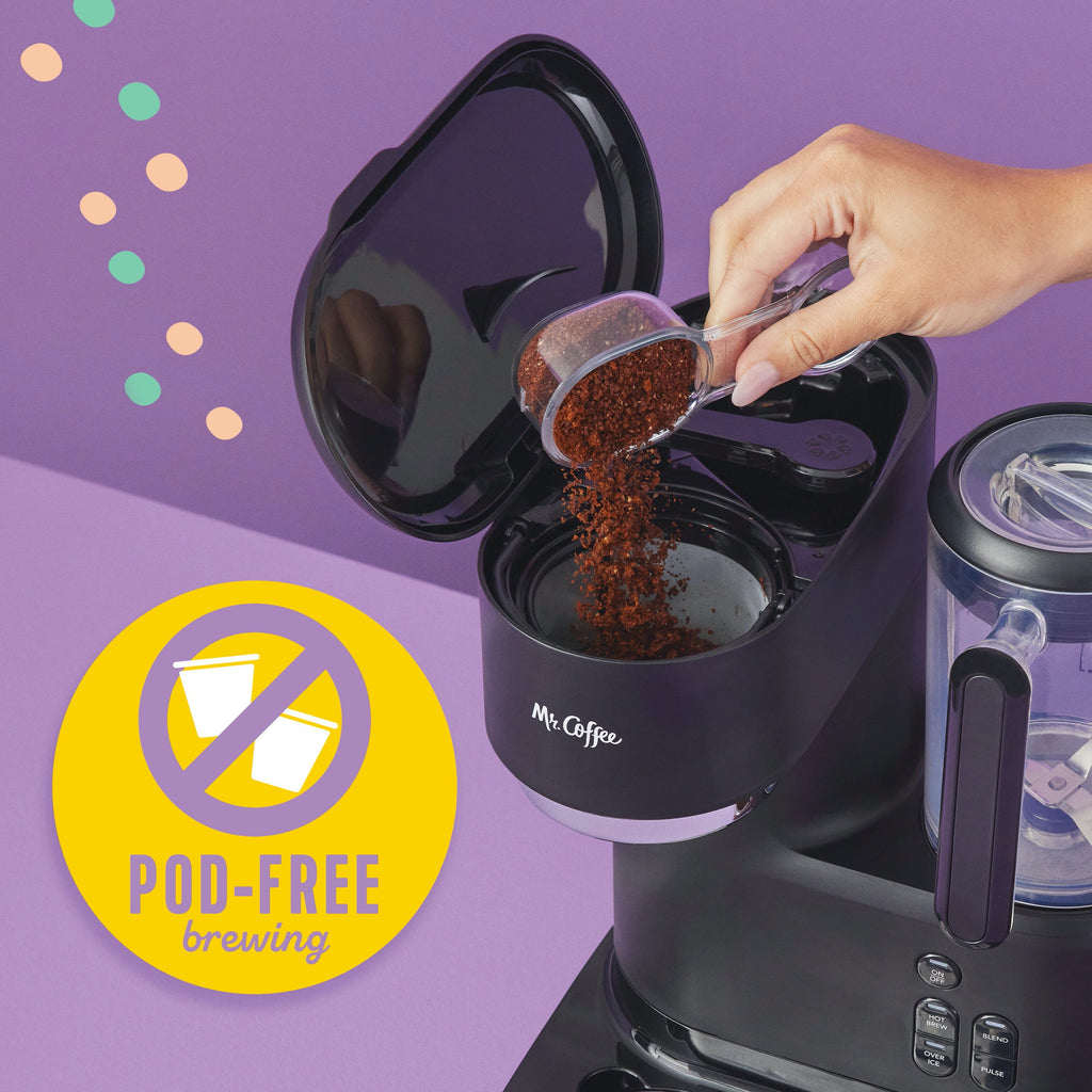 Black blender coffee maker with pitcher opening while coffee grounds are poured inside