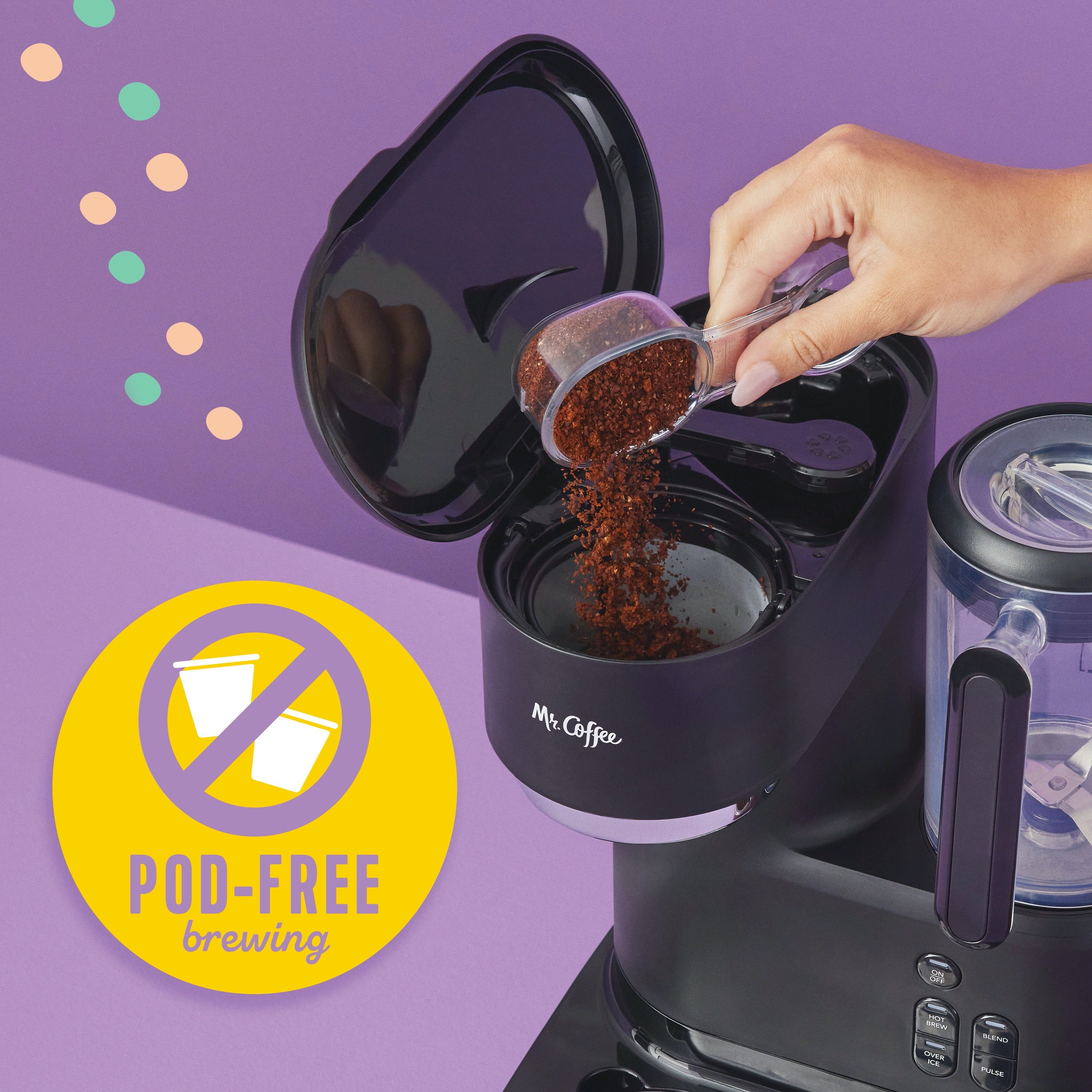 Black blender coffee maker with pitcher opening while coffee grounds are poured inside